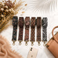 Set of patterned strap options on a marble surface with a phone and handbag.