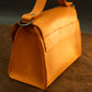 The Signature Flap leather bag worn crossbody, lifestyle editorial photo