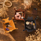Three sculptural leather car key holder trays in mustard yellow, terracotta brown, and navy blue, styled on a wooden table with dried flowers and car keys.
