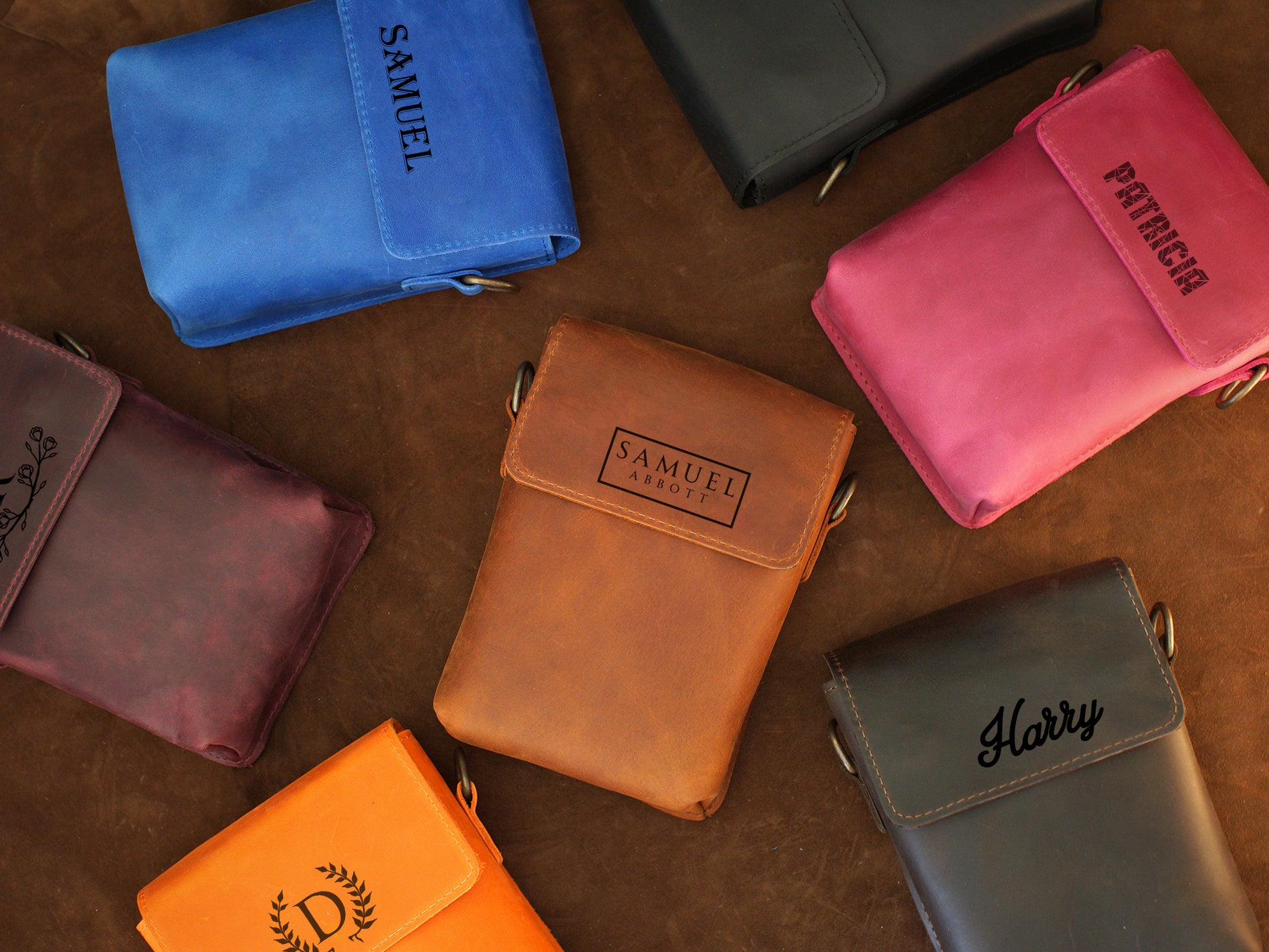 Collection of personalized leather pouches on a wooden surface