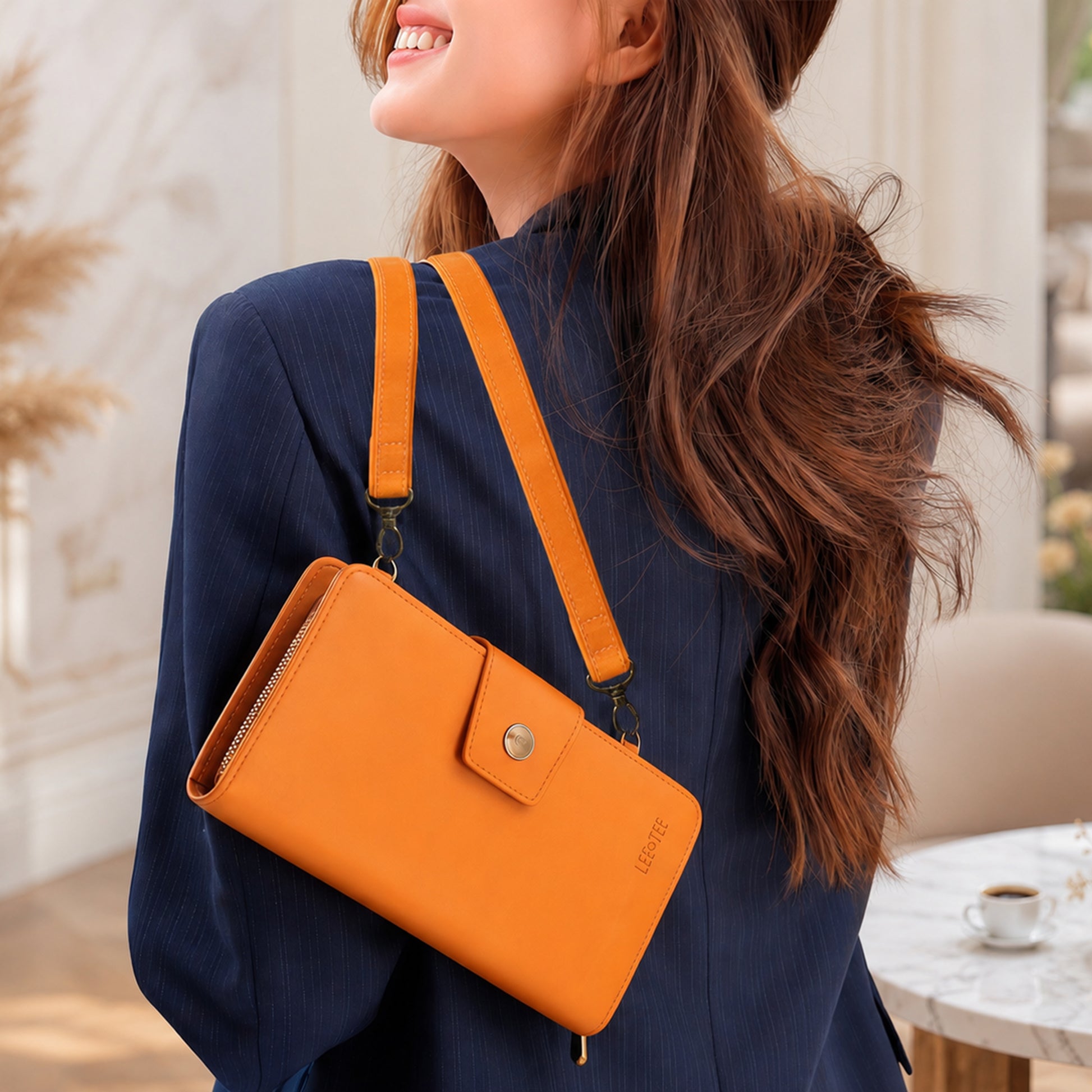 Woman wearing an orange crossbody bag with a blurred indoor background