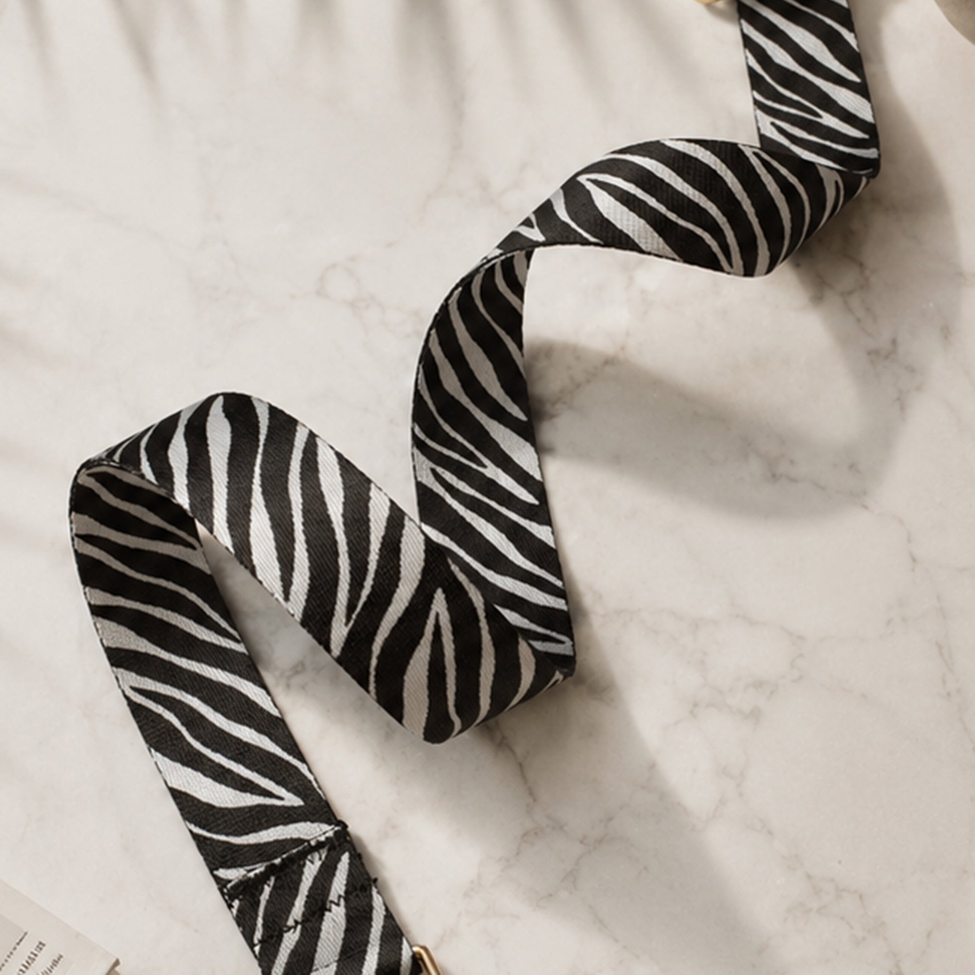 Black and white zebra-striped ribbon on a marble surface