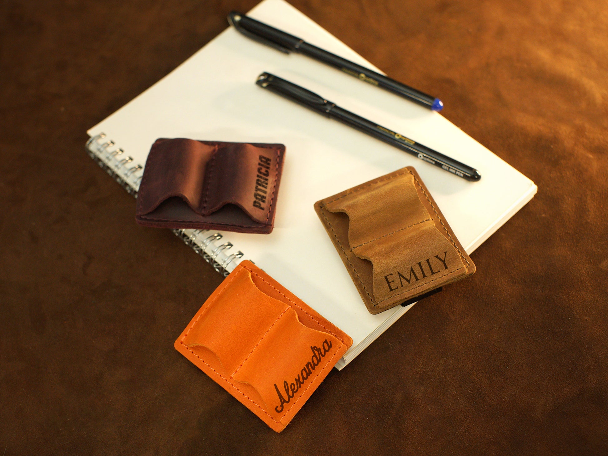 Person using personalized leather pen holder on notebook, lifestyle photo