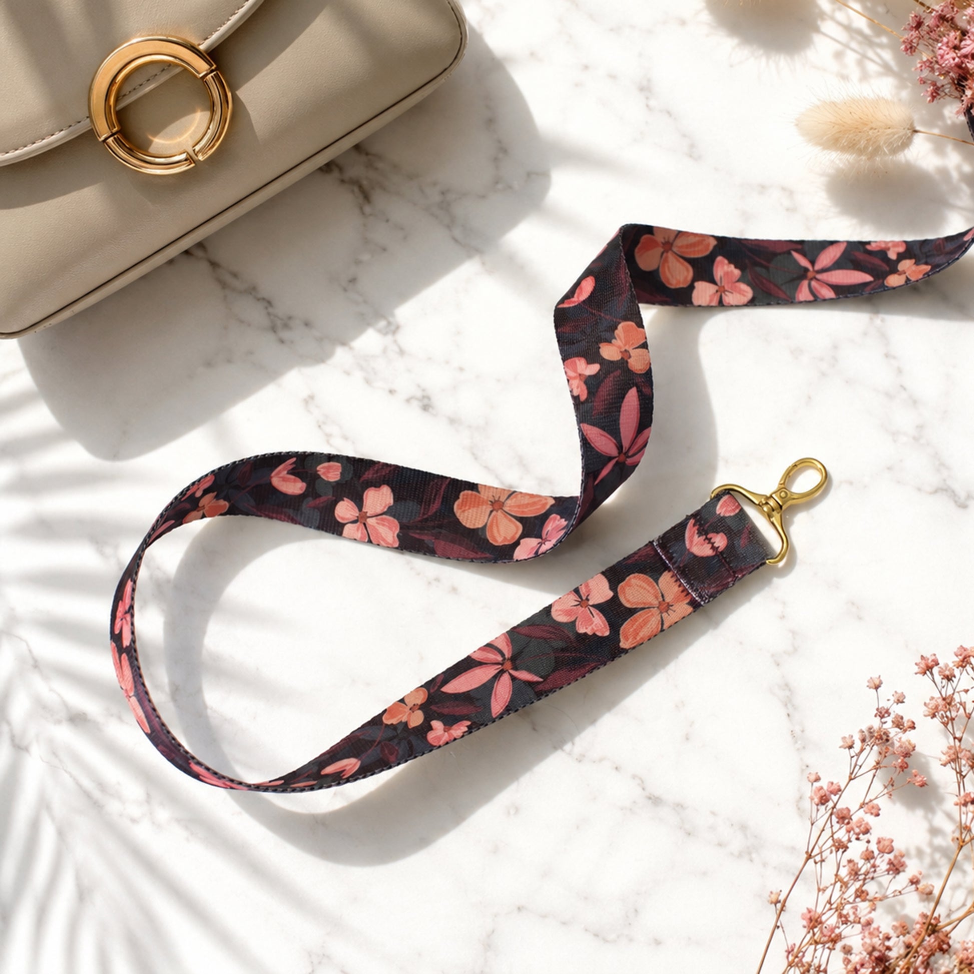 Floral patterned lanyard with gold clasp on a marble surface