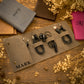 A styled flat-lay of several leather wallets and card holders arranged on a rustic wooden surface with dried flowers, rope, and pinecones.