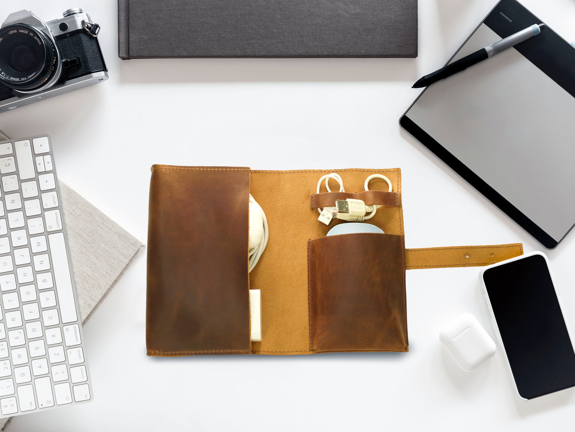 Person carrying personalized leather cable organizer, lifestyle shot