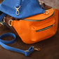 The leather crossbody sling in use outdoors, warm earthy tones