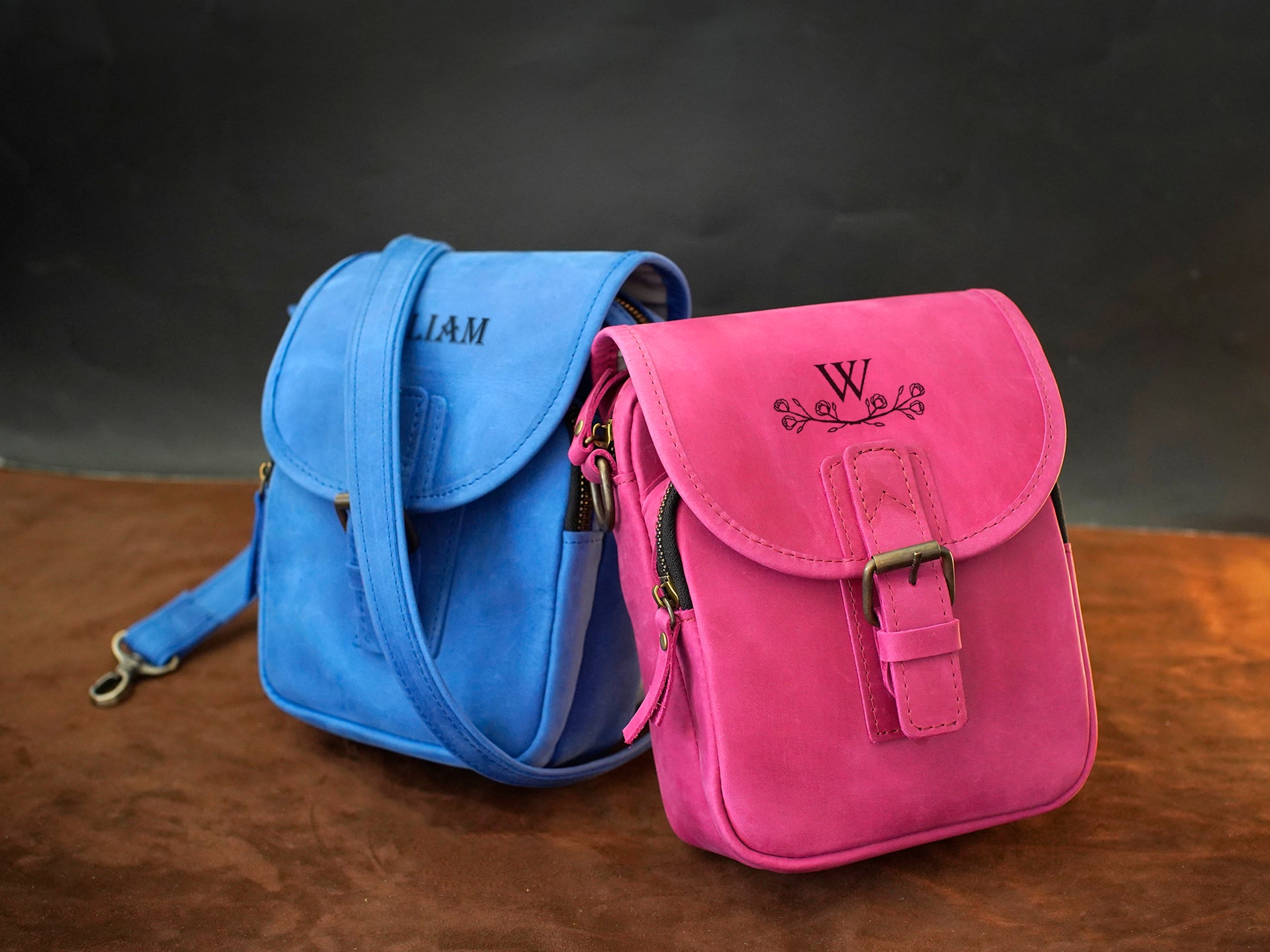 Blue and pink bags with visible branding on a wooden surface and dark background