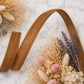 Brown leather belt with dried flowers on a marble surface