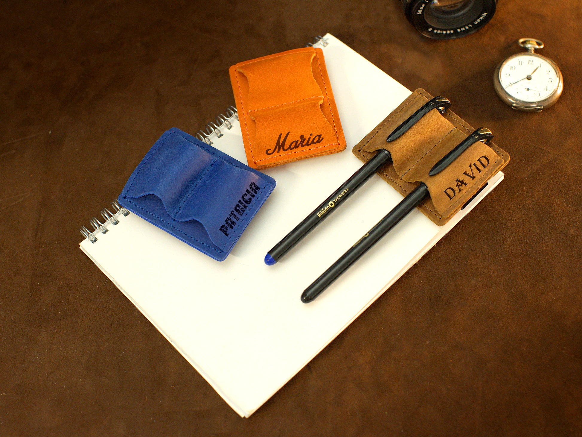 Collection of personalized leather pen holders with engravings