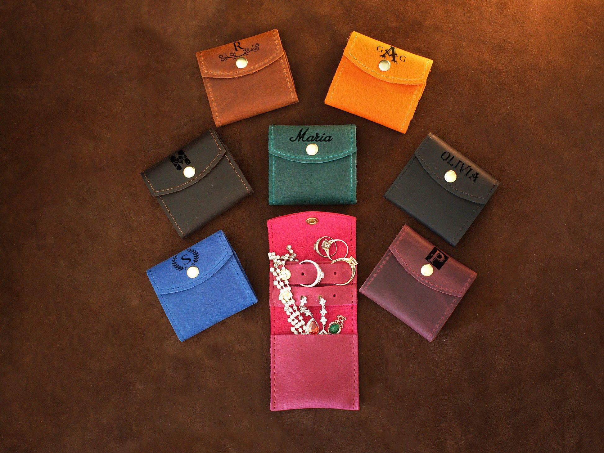 Collection of personalized leather jewelry pouches with engravings