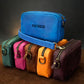 Stack of colorful leather bags with 'Patricia' branding on a dark background