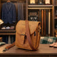 Brown leather bag on a wooden table with a background of clothing and shoes.