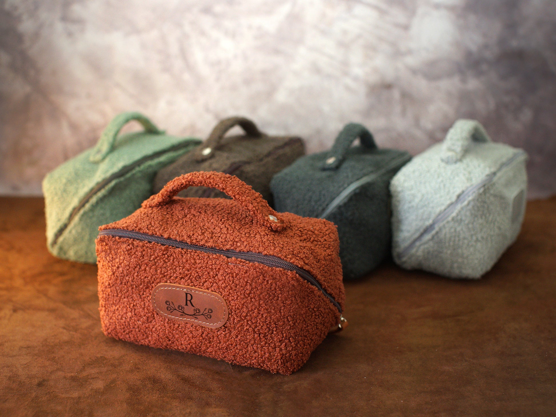 Four small bags in different colors on a wooden surface with a blurred background