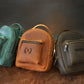 Leather mini backpack collection with personalized engravings, lifestyle flat lay