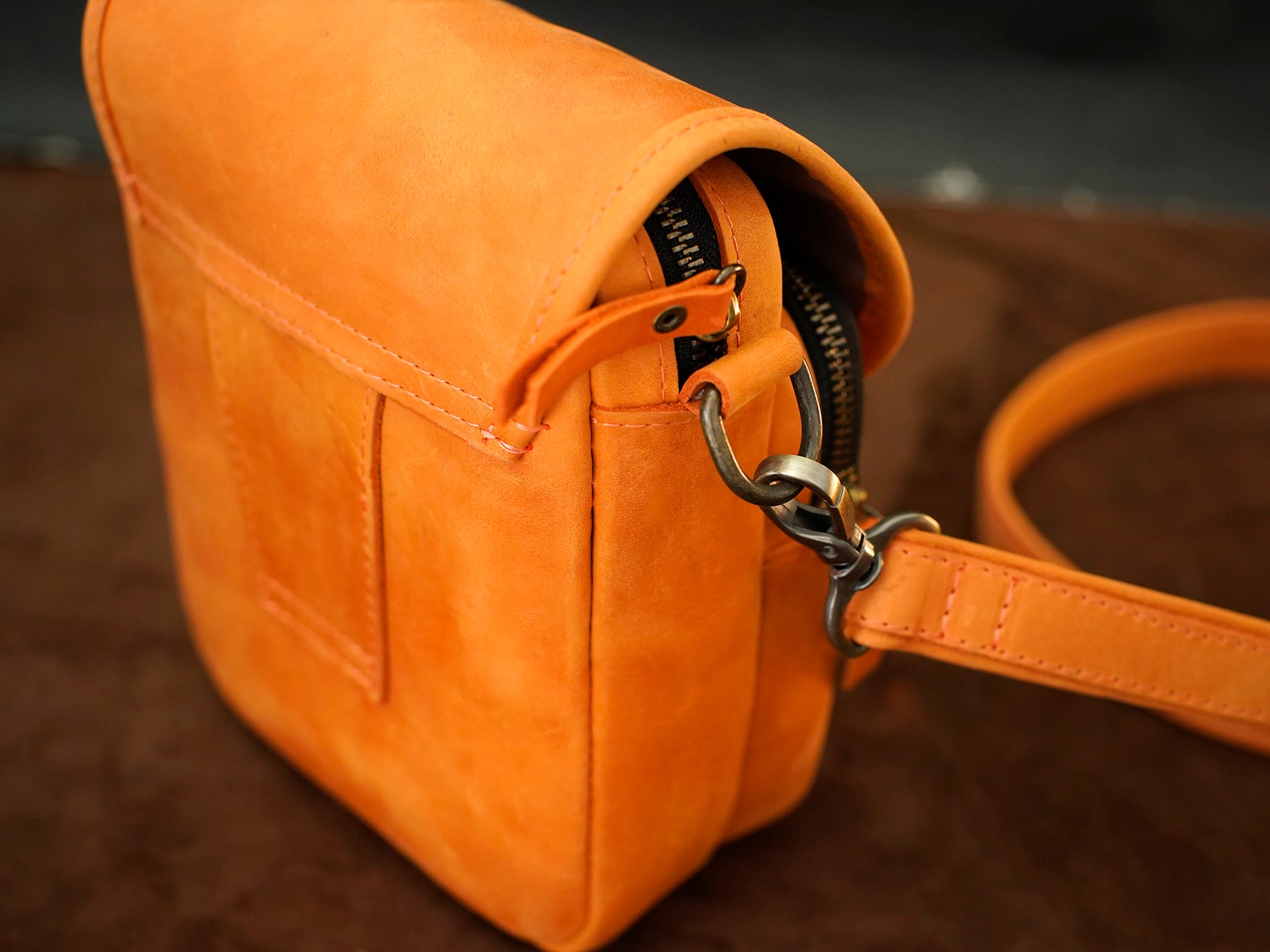Close-up of a yellow leather bag with a zipper on a blurred background