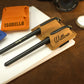 Multiple leather pen loops with monogram initials on textured surface