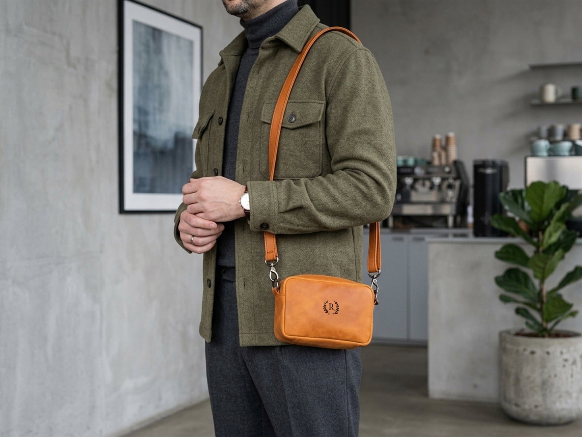 Person wearing a green coat with an orange crossbody bag in a modern interior setting