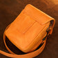 Orange leather crossbody bag on a brown background