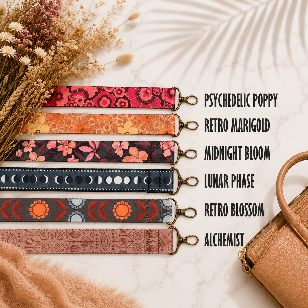 Set of colorful strap designs with names next to a brown handbag on a textured surface.