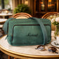 Green bag with 'Michael' embroidery on a table with sunglasses and a cup of coffee in a café setting.