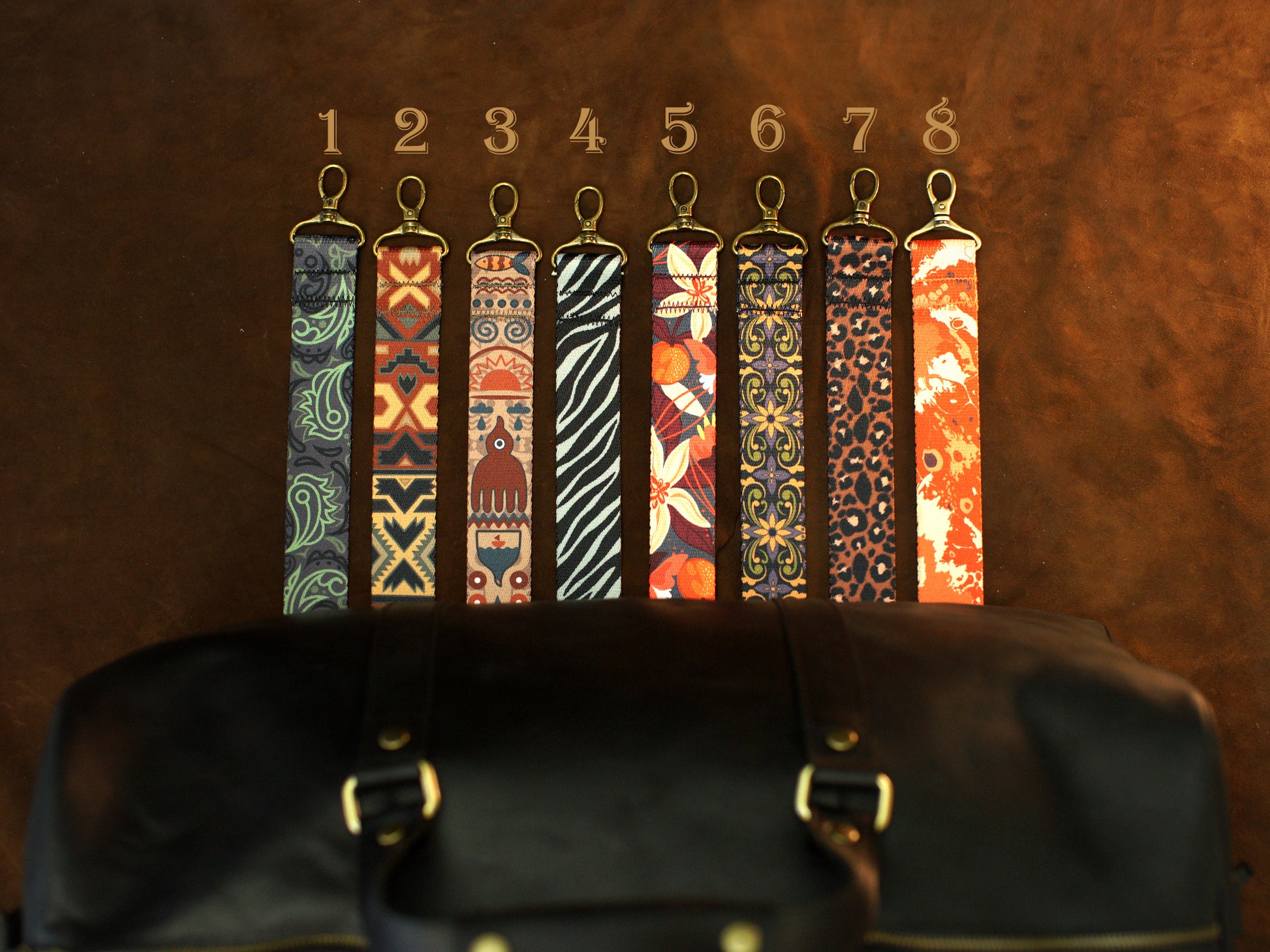 Set of colorful keychains displayed on a leather surface