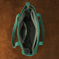 Green handbag with gold zipper on a brown background