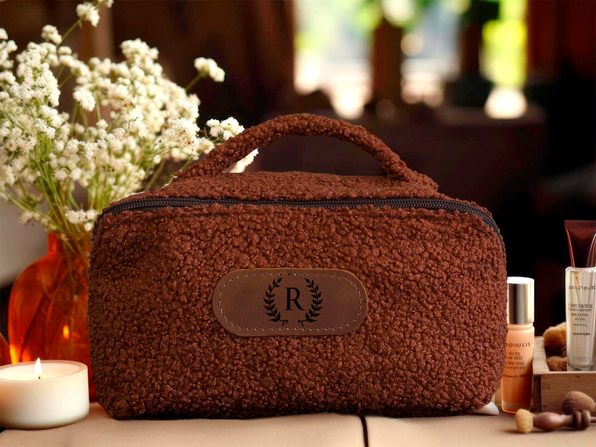 Brown textured cosmetic bag with a logo on a blurred background