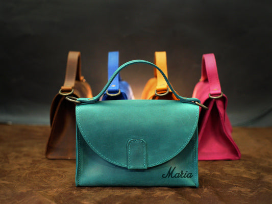 Leather handbag collection with personalized engravings, lifestyle flat lay