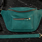 Emerald waist bag on a dark marble surface with a phone and wallet nearby
