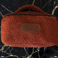 Brown textured bag with leather patch on a black marble surface