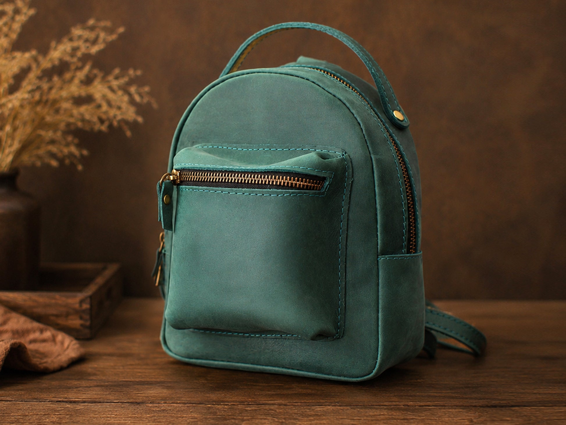 Teal backpack on a wooden surface with a brown background