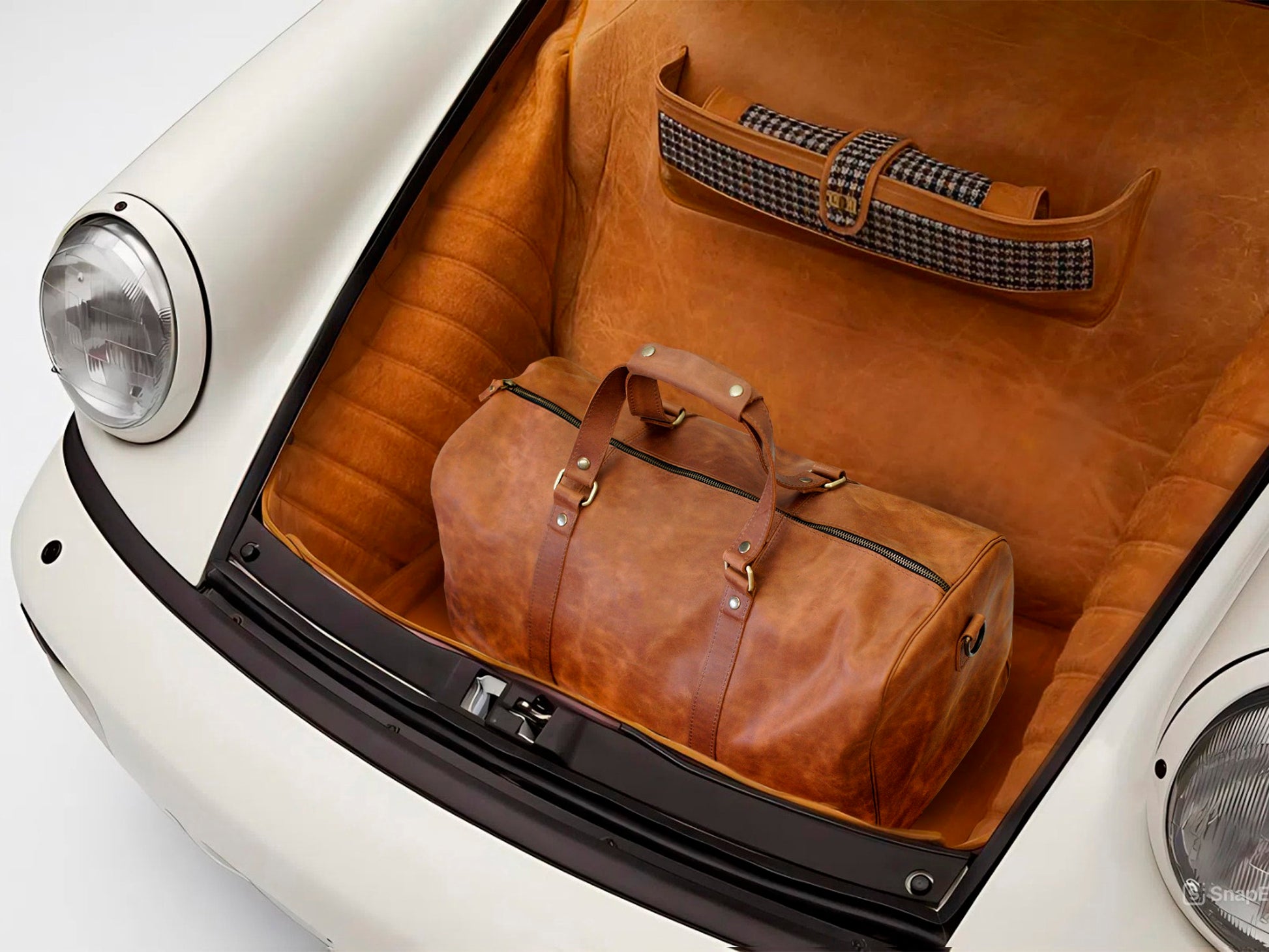 Brown leather duffel bag in the trunk of a vintage car