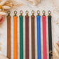 Set of colorful lanyards with gold clasps on a marble surface.
