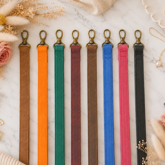 Set of colorful lanyards with gold clasps on a marble surface.
