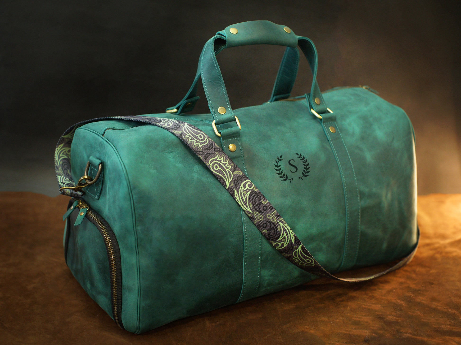 Leather duffle bag collection with personalized engravings, lifestyle flat lay