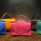 Multiple leather handbags with monogram initials on textured surface