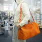 Person holding an orange duffel bag in a gym setting