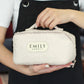 Person holding a textured pouch with 'EMILY ARBOUD' branding.