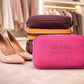 Pink crossbody bag with 'Olivia' branding next to high heels in a clothing store setting