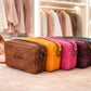Colorful leather crossbody with 'Maria' branding on a wooden surface, with high heels and a wardrobe in the background.