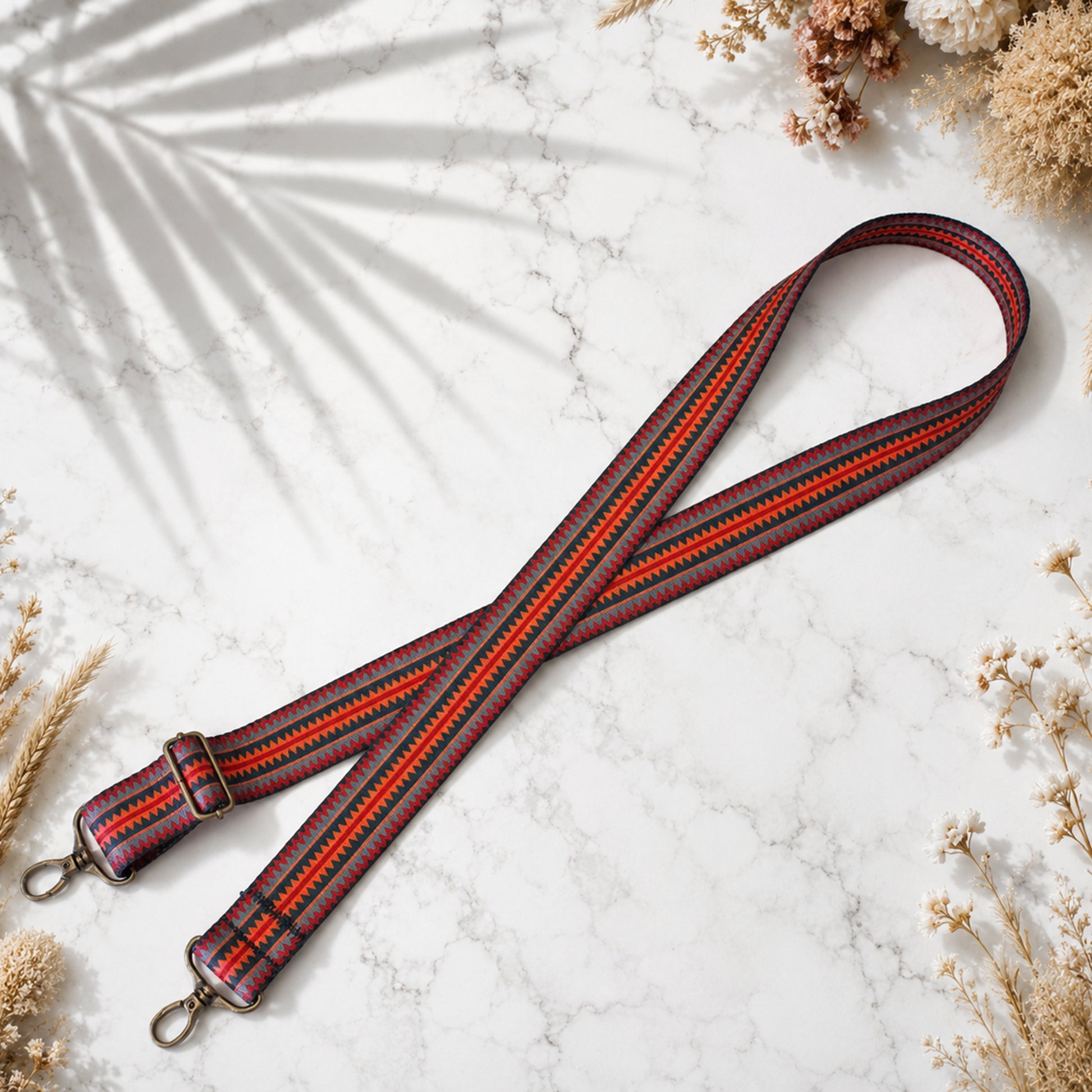 Striped leather strap with floral decorations on a marble surface