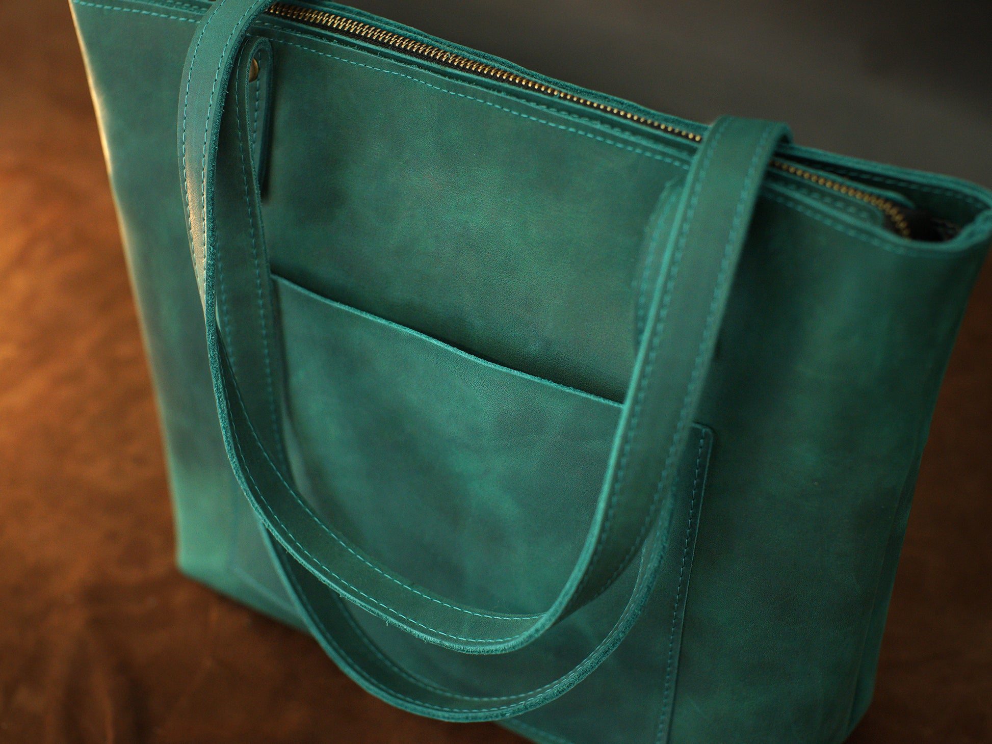 Brown leather zippered tote bag with custom monogram engraving, front view