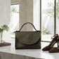Chocolate handbag and brown high heels on a marble surface with a blurred indoor background