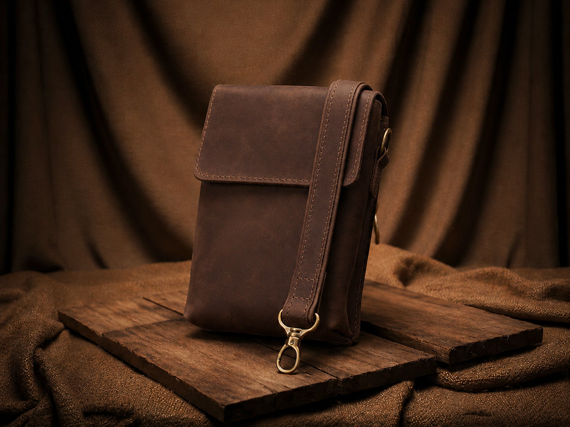 Brown leather bag on a wooden surface with a brown fabric background