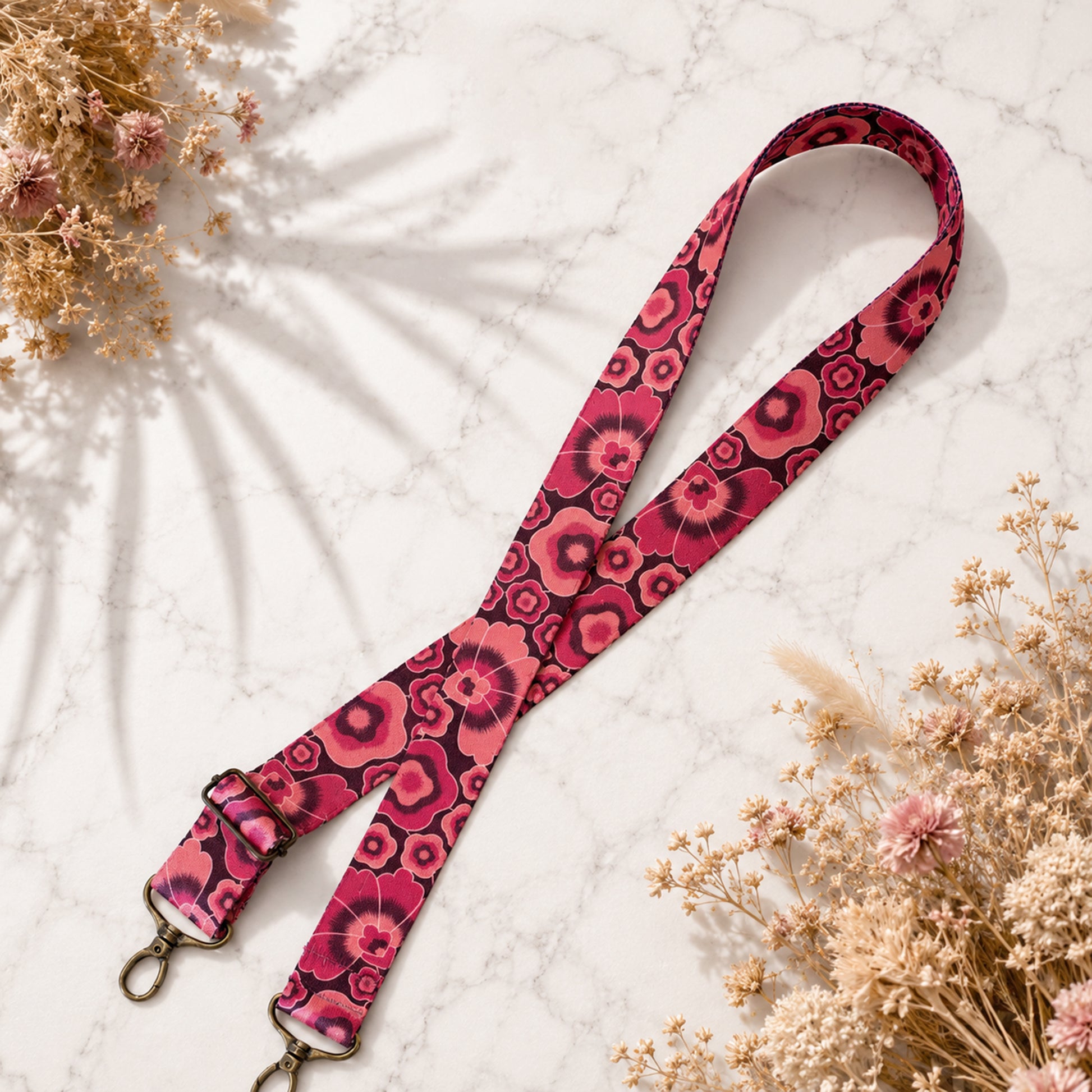 Pink floral patterned strap on a light background with dried flowers