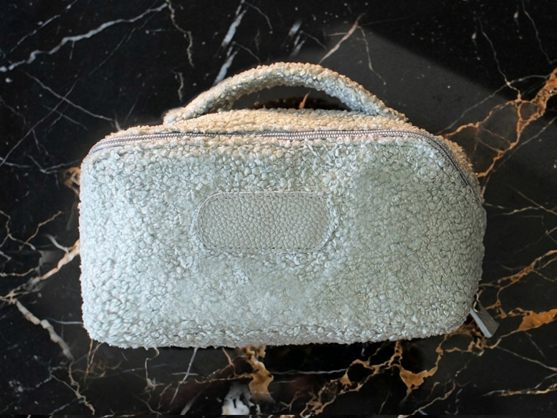 Textured handbag on a black marble surface