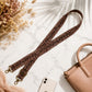 Leopard print strap with gold hardware on a marble surface with a phone and handbag.
