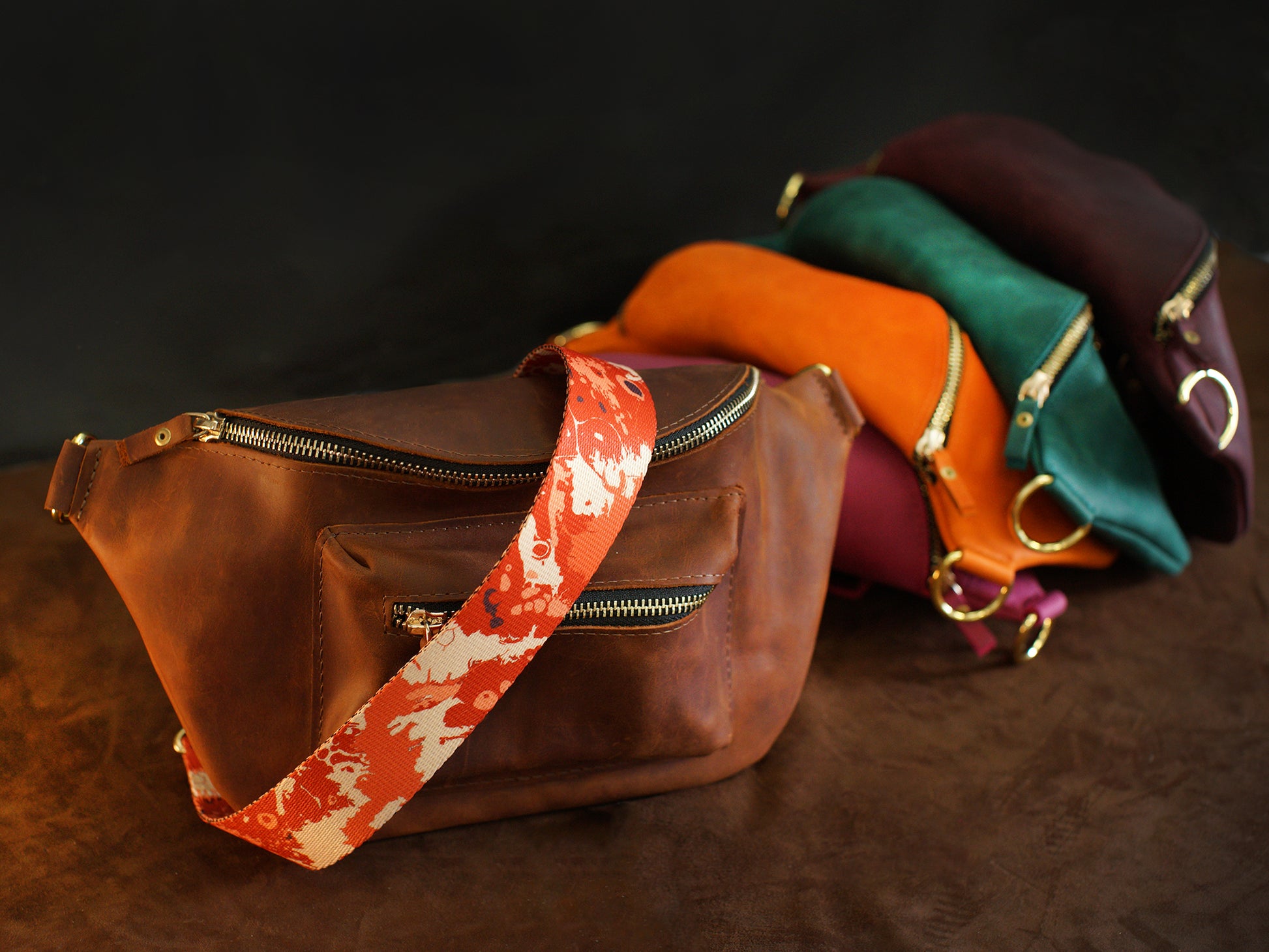 Set of leather bags with colorful straps on a dark background
