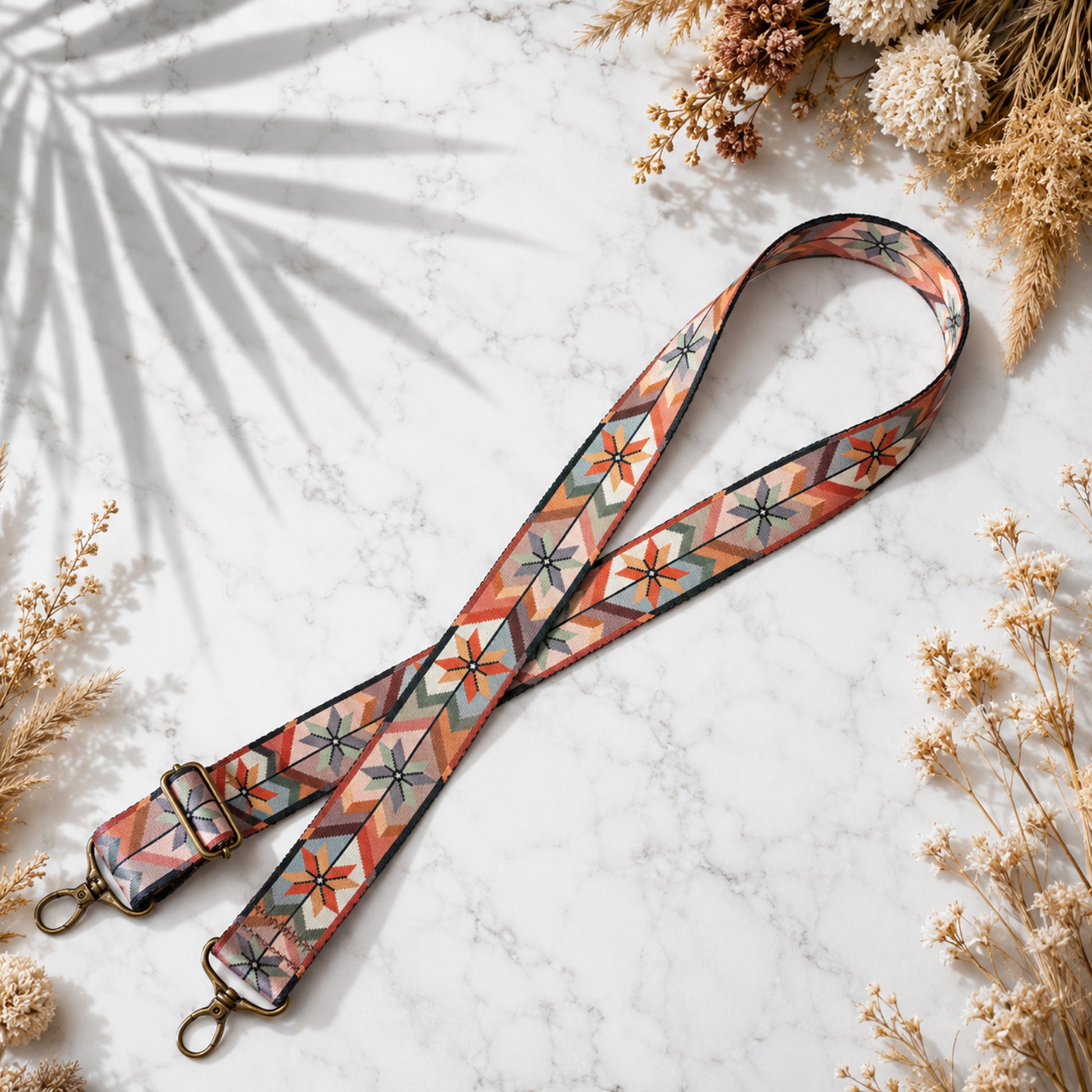 Floral patterned strap on a marble surface with dried flowers